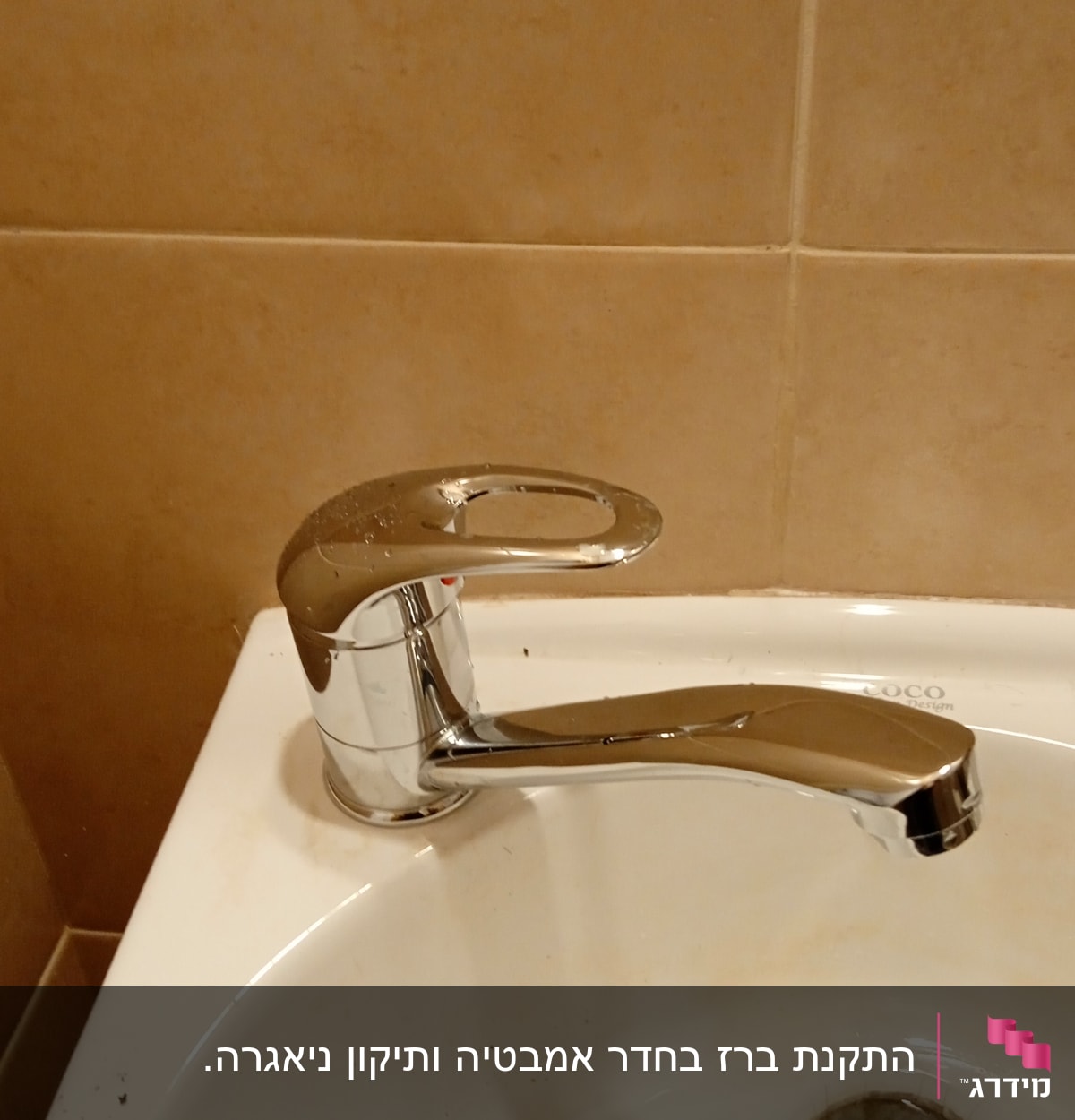 ברז כרום על כיור לבן עם כתמים